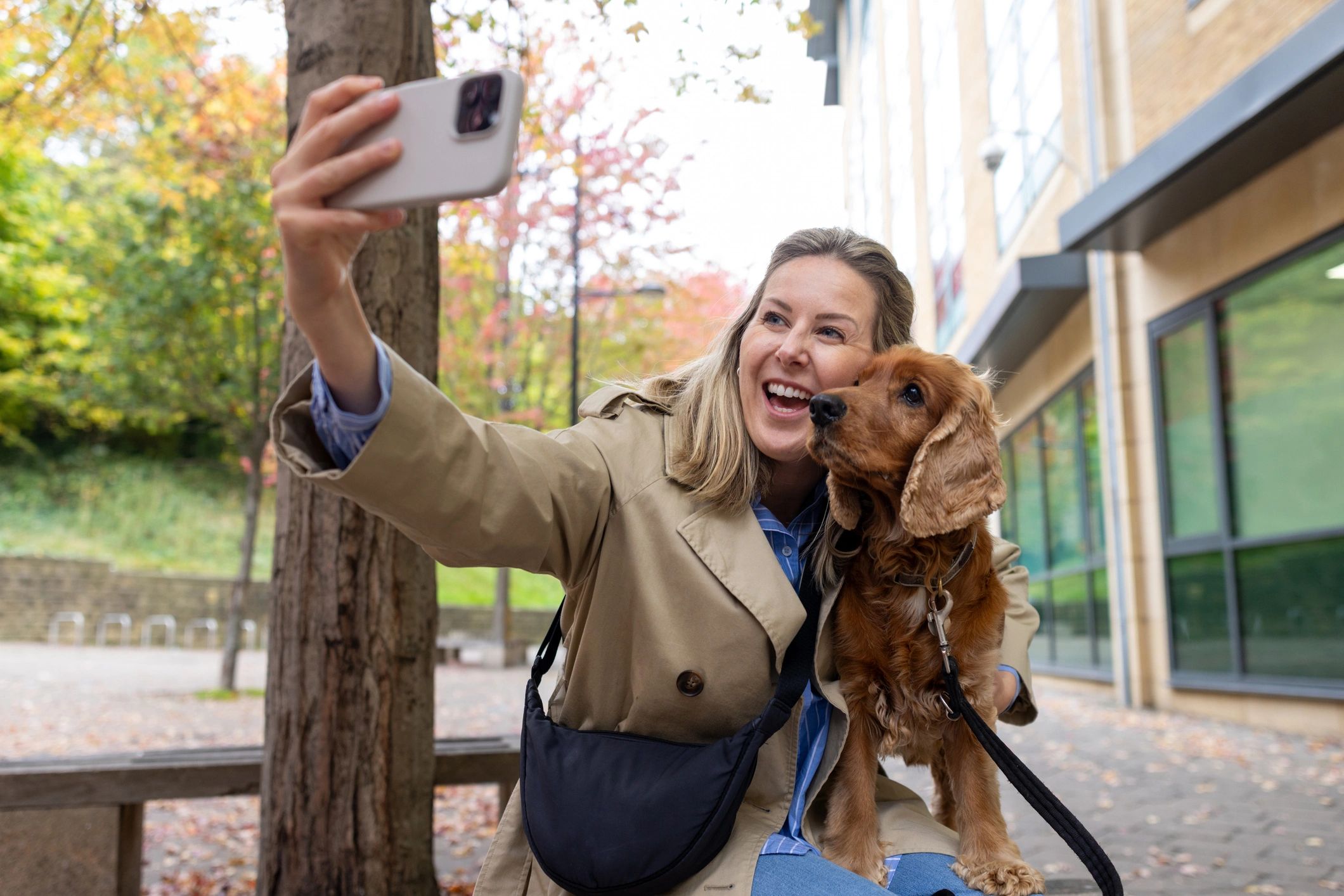 Woman with a dog using a phone outdoors